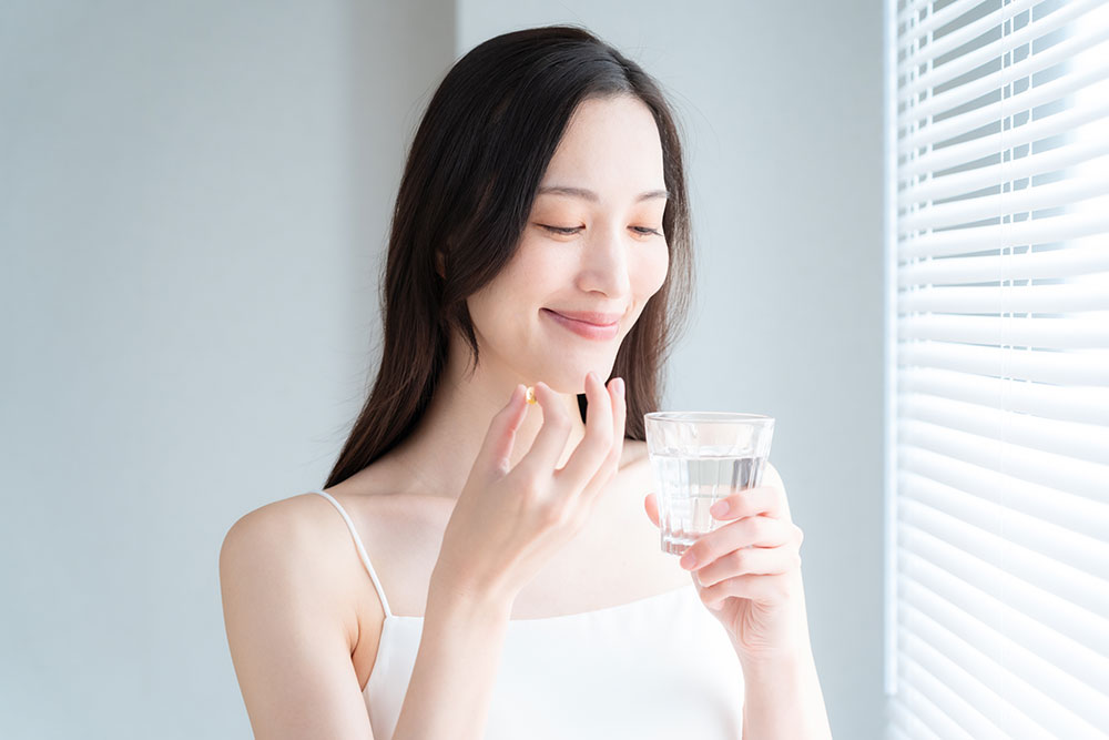 薬を飲む女性